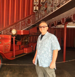 a man standing in front of a red fire truck