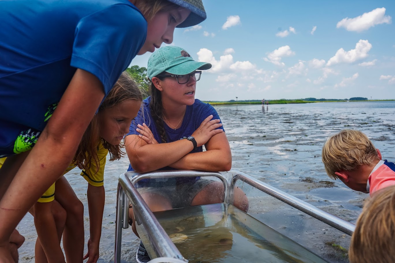 a group of people standing around a boat in the water